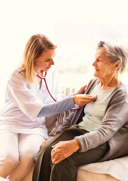 doctor checking heart beat of a senior woman